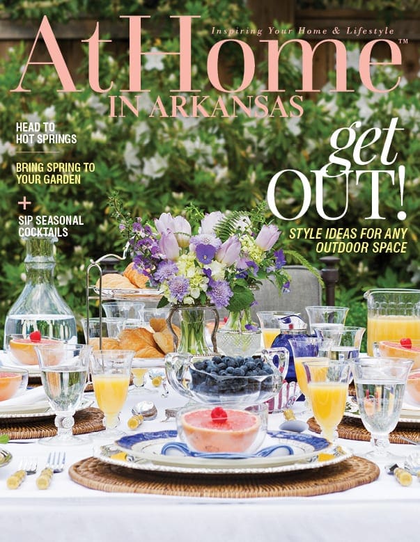 At Home in Arkansas magazine cover with headline 'get OUT!' and outdoor dining spread.