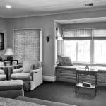 Living room with two armchairs, ottoman, and window seat with storage.