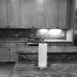 Kitchen with light wood cabinets, granite countertops, and a paper towel holder on the island.