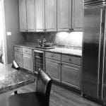 Kitchen with light wood cabinets, wine fridge, and stainless steel refrigerator.