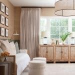 Living room with grasscloth wallpaper, daybed, distressed wood cabinet, and large drum pendant