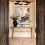 Dark wood entryway with artwork, plant, and console table.