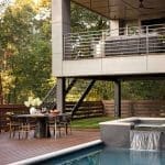 Modern deck with pool, stairs, and outdoor furniture.