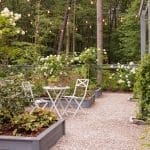 Outdoor seating area with rose bushes and string lights.
