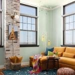 Brick wall, teal wall, window, sofa, and rug.