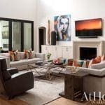 Modern living room with sectional sofa, fireplace, and artwork.