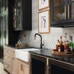 Dark cabinets, marble island, and a wet bar with glassware.