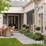 Exterior shot of a gray-painted house with a covered porch and patio.
