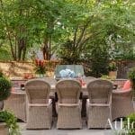 Brick patio with wicker dining set and outdoor decor.