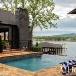 Dark wood house with pool and dock overlooking lake, Arkansas.
