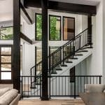 Dark wood and black metal staircase with large windows.