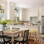 White kitchen with island, subway tile, and yellow floral curtains.