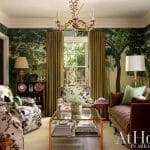 Living room with green wallpaper, chandelier, and patterned sofa.