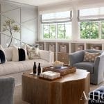 Light-filled living room with textured wall paneling, sofa, and wooden coffee table.