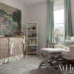 White nursery with landscape painting, gold crib, and green curtains.