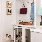 White built-in closet with dog crates and decorative items.