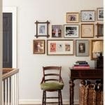 Wall display of framed photographs and books, wooden chair, and woven basket.