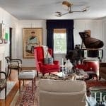 Living room with a red armchair, piano, and patterned rug.