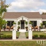 White house with dark front door, Arkansas address, and landscaping.