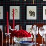 Dining room with plaid wallpaper, framed artwork, candles, and wine glasses.