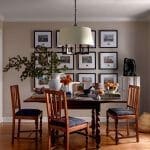 Dining room with wooden chairs, framed artwork, and a large pendant light.