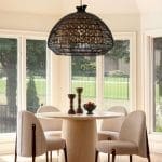 Black woven pendant light above a wooden dining table with chairs.