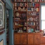 Tall, dark wood bookshelf filled with books and objects.