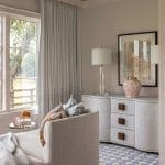 Light-colored seating area with patterned ceiling and window.