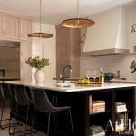 Kitchen island with dark wood cabinetry, bar stools, and a wine rack.