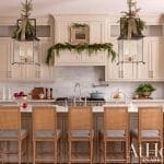 White kitchen with cabinets, marble countertops, and pendant lighting.