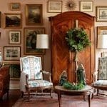 Wooden armoire with framed artwork and a wreath.