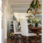 Dining room with ornate chandelier, chairs, and Christmas decor.