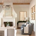 Neutral living room with wood beams, fireplace, and artwork.
