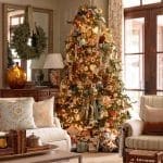 Decorated Christmas tree in a living room with wooden furniture and patterned pillows.