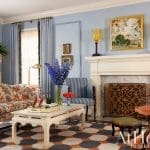 Living room with blue walls, marble fireplace, and patterned furniture.