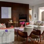 Dark wood paneling, fireplace, and seating area in a living room.