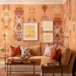 Orange and gold patterned wallpapered living room with furniture.