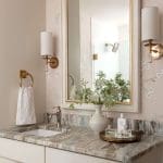 Pink marble vanity with gold mirror and Chanel perfume.