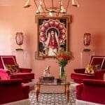 Pink walls with gold light fixture and framed artwork.
