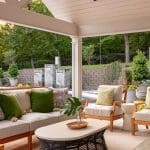 Covered patio with sectional sofa, chairs, coffee table, and water feature