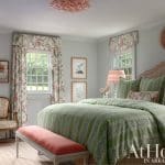 Green and white striped bed with floral bedding and curtains.