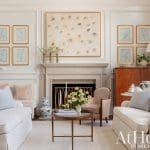 Cream-colored walls with framed floral artwork and a marble fireplace.