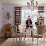 Dining room with patterned wallpaper, purple curtains, and a gold chandelier.