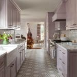 Pink kitchen with patterned tile floor and cabinetry.