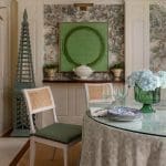 Wallpapered dining room with a patterned table and green decor.