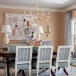 Gold chandelier, light blue chairs, and a patterned table in a formal dining room.