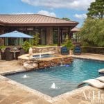 Stone house with pool, patio, and landscaping in Arkansas.