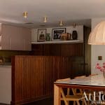 Wooden paneling, marble countertop, and pendant light in a kitchen.