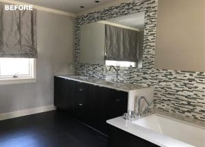 Gray tiled wall with mirror and window, black vanity, and white countertop.