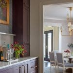 Dark wood bar cabinet with gold hardware and tulips.